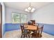 Charming dining area with a round wood table set beneath a chandelier and a bright window at 17801 Simmons Rd, Lutz, FL 33548