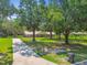 Well-maintained home features a metal roof, mature trees, and a long driveway, set against a backdrop of greenery and a clear blue sky at 17801 Simmons Rd, Lutz, FL 33548