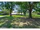 Spacious front yard with mature trees framing the home, enhancing curb appeal and providing shade at 17801 Simmons Rd, Lutz, FL 33548