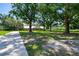 Wide view of the front yard and tree-lined property leading to the brick home at 17801 Simmons Rd, Lutz, FL 33548