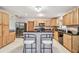 Kitchen features custom wood cabinets, black granite countertops, stainless steel appliances, an island, and white tile floors at 17801 Simmons Rd, Lutz, FL 33548
