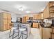 Kitchen features custom wood cabinets, black granite countertops, stainless steel appliances, an island, and white tile floors at 17801 Simmons Rd, Lutz, FL 33548