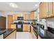 A kitchen with custom wood cabinets, black granite countertops, stainless steel sink, and white tile floors at 17801 Simmons Rd, Lutz, FL 33548