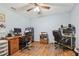 Bright office with a ceiling fan, two desks, and wood laminate flooring at 17801 Simmons Rd, Lutz, FL 33548