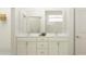Elegant bathroom features a double vanity with marble countertop and modern fixtures, alongside a glass-enclosed shower at 18477 Serene Lake Loop, Lutz, FL 33548
