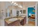 Bright bathroom featuring a double vanity with granite counters, and an open doorway to a bedroom at 19412 Heritage Harbor, Lutz, FL 33558