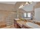 Bathroom featuring double sinks, granite countertops, and glass block shower, creating a spa-like experience at 19412 Heritage Harbor, Lutz, FL 33558