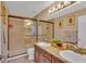Bathroom features a double vanity with granite counters and a shower with glass doors at 19412 Heritage Harbor, Lutz, FL 33558