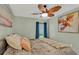 Relaxing bedroom with blue curtains, a ceiling fan, and a tranquil painting at 19412 Heritage Harbor, Lutz, FL 33558