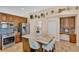 Kitchen area with wooden cabinets, tile backsplash, stainless steel appliances, and island with seating at 19412 Heritage Harbor, Lutz, FL 33558