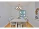 Cozy dining room with white table and chairs, chandelier, and plenty of natural light at 2316 Lyndhurst Dr, Sun City Center, FL 33573