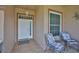 Welcoming front porch featuring tile flooring, chairs, and a storm door at 2316 Lyndhurst Dr, Sun City Center, FL 33573