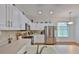 Well-lit kitchen features stainless appliances, white cabinets, and a view to the eating area at 2316 Lyndhurst Dr, Sun City Center, FL 33573