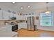 Well-lit kitchen features stainless appliances and white cabinets, and is adjacent to the eat-in nook at 2316 Lyndhurst Dr, Sun City Center, FL 33573