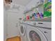 Bright laundry room with white appliances and shelving for storage at 2316 Lyndhurst Dr, Sun City Center, FL 33573
