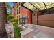 Elegant entryway with a decorative gate, lush greenery, and brick pathway leading to the building's facade at 2410 W Azeele St # 214, Tampa, FL 33609