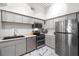 Modern kitchen featuring stainless steel appliances, gray cabinets, white subway tile backsplash and luxurious marble flooring at 2410 W Azeele St # 214, Tampa, FL 33609