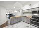 Bright kitchen featuring stainless steel appliances, gray cabinets, butcher block island, and marble flooring at 2410 W Azeele St # 214, Tampa, FL 33609