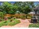 Backyard brick patio features lush gardens, wooden privacy fence and shade trees at 2484 Whitman St, Clearwater, FL 33765