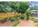 Backyard brick patio with lush landscaping, privacy fence, and mature trees at 2484 Whitman St, Clearwater, FL 33765