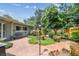 Landscaped backyard featuring mature trees, a brick patio, and a peaceful setting at 2484 Whitman St, Clearwater, FL 33765
