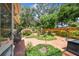 Landscaped backyard features a brick patio, lush plants, and mature shade trees at 2484 Whitman St, Clearwater, FL 33765
