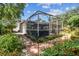 Landscaped backyard features brick paver path and access to screened-in lanai with hot tub at 2484 Whitman St, Clearwater, FL 33765
