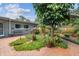 Brick patio features lush landscaping including potted plants, bench, and mature trees at 2484 Whitman St, Clearwater, FL 33765