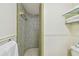 The bathroom features tiled walls and an open, glass shelving for towel storage at 2484 Whitman St, Clearwater, FL 33765