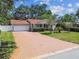 Charming home with brick driveway, manicured lawn, and mature trees at 2484 Whitman St, Clearwater, FL 33765