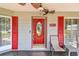 Close-up of the home's red front door flanked by red shutters and lounge seating at 2484 Whitman St, Clearwater, FL 33765