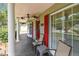 Front porch features red door, matching shutters, and outdoor lounge seating at 2484 Whitman St, Clearwater, FL 33765