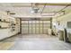 Bright garage featuring a large garage door and open shelving storage at 2484 Whitman St, Clearwater, FL 33765