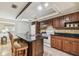 Well-lit kitchen with dark wood cabinets, granite countertops, and tile backsplash at 2484 Whitman St, Clearwater, FL 33765