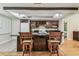 A kitchen with a wine rack, white refrigerator, wooden cabinets, and wooden chairs at 2484 Whitman St, Clearwater, FL 33765