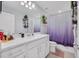 Stylish bathroom features white cabinets and drawers, double sinks, and colorful shower curtain at 2781 Dolores Home Ave, Valrico, FL 33594
