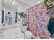 Cozy bathroom features a white vanity, toilet, and a colorful shower curtain at 2781 Dolores Home Ave, Valrico, FL 33594