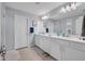 Well-lit bathroom features double sinks, large mirror, and white cabinets at 2781 Dolores Home Ave, Valrico, FL 33594