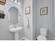 Charming powder room features a pedestal sink, matching framed mirror, and crisp white fixtures at 2781 Dolores Home Ave, Valrico, FL 33594