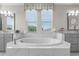 A luxurious bathroom featuring a large soaking tub and dual vanity sinks at 28512 Picana Ln, Wesley Chapel, FL 33543