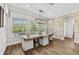 An open dining room with large windows overlooking the pool and a decorative light fixture at 28512 Picana Ln, Wesley Chapel, FL 33543
