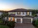 Exterior of a stately two-story home with a three-car garage and manicured landscaping at 28512 Picana Ln, Wesley Chapel, FL 33543
