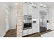 A gourmet kitchen features stainless steel appliances and custom white cabinetry with brick accent wall at 28512 Picana Ln, Wesley Chapel, FL 33543