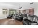 Living room with brick accent wall, dark hardwood floors, and neutral wall colors at 28512 Picana Ln, Wesley Chapel, FL 33543