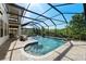 Luxurious screened-in pool and spa with water features, surrounded by a stone patio at 28512 Picana Ln, Wesley Chapel, FL 33543
