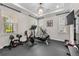 Bright workout room featuring large windows, tray ceiling, and chandelier at 28512 Picana Ln, Wesley Chapel, FL 33543