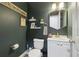 Stylish half-bathroom with dark green walls, white fixtures, and decorative gold mirror at 2914 W Gandy Blvd # C, Tampa, FL 33611