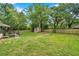 Expansive backyard featuring a storage shed, a wooden fence, and mature trees providing shade at 316 Jenkins Ave, Brooksville, FL 34604
