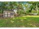 Large backyard features a well-maintained lawn, storage shed, and privacy fence at 316 Jenkins Ave, Brooksville, FL 34604