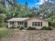 Well-kept one-story home with shutters, front garden and established trees at 316 Jenkins Ave, Brooksville, FL 34604